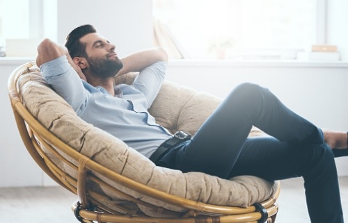 A man sitting on a couch happy and relaxing.