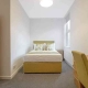 In this furnished bedroom in Kennington Park, there's a bed with pillows at the head, and a window on the side.