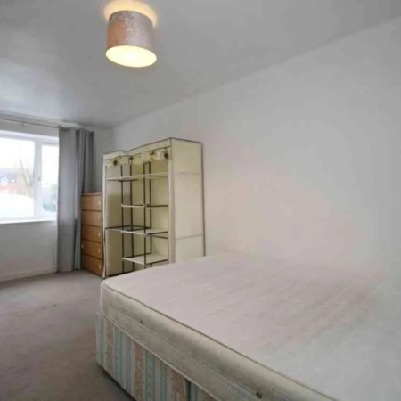 In this furnished spacious room in Battersea, you'll find a bed with cabinets positioned at the foot, and the window is situated at the far end.