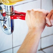 A hand turning the pipe using a tool in the Burst Pipes in Rental Properties blog.