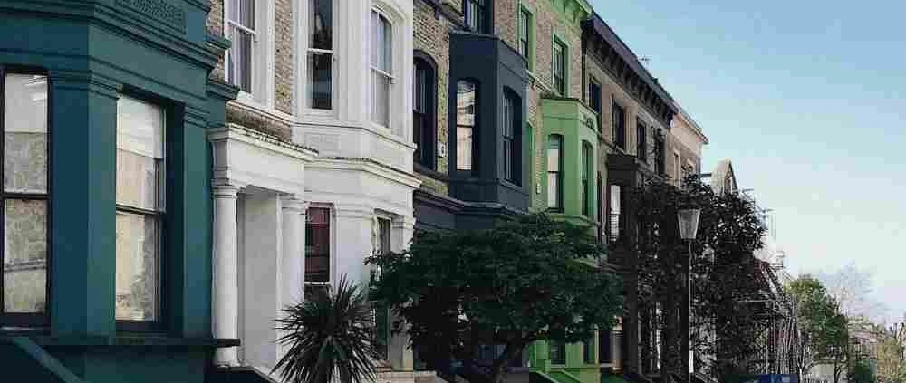 Apartment in different colors and cars along the street in this blog about London's Shared Housing.