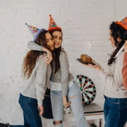 A group of people celebrating with a party hat and a cake in this blog about Shared Living Unveiled.