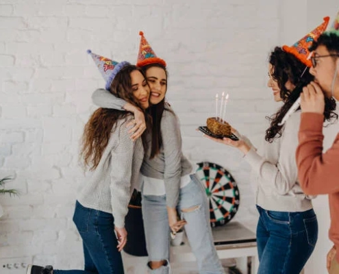 A group of people celebrating with a party hat and a cake in this blog about Shared Living Unveiled.