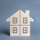 A wooden miniature house with four divided windows is featured in this blog on Strategies for Shared Flat Management.